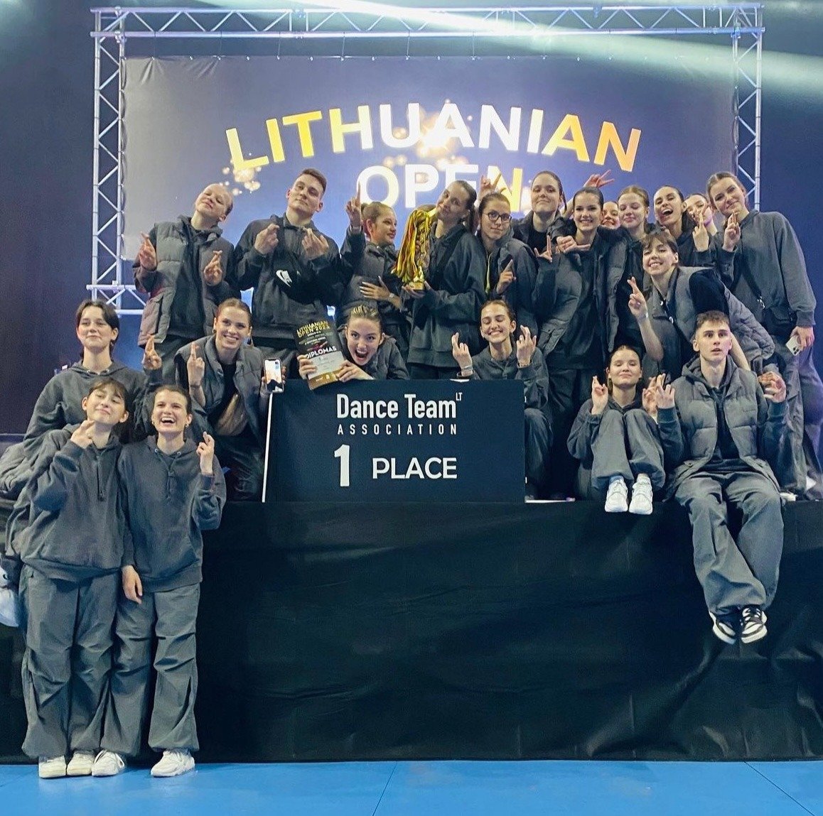 A youth dance team celebrates winning first place at the Lithuanian Open Dance Team Association competition.